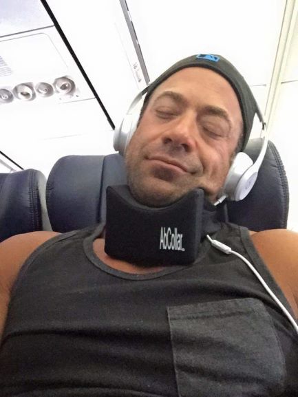 A Man Is Resting on an Airplane, Headphones On, Enjoying a Peaceful Sleep