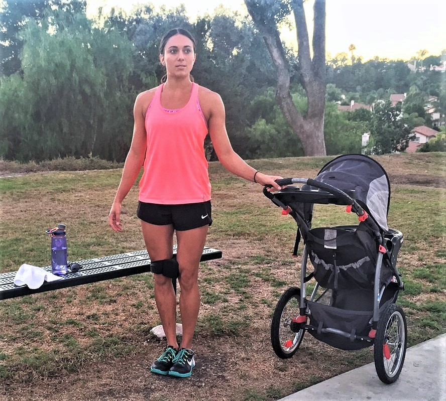 Woman in Pink Top Holding Baby Stroller.