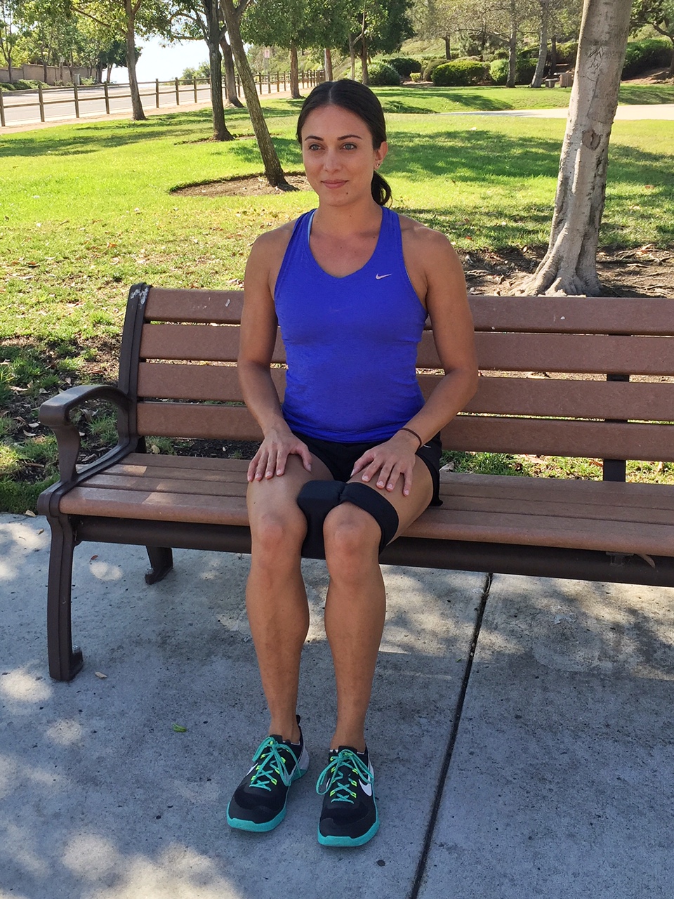 A Woman Sitting on a Bench With Her Legs Crossed.